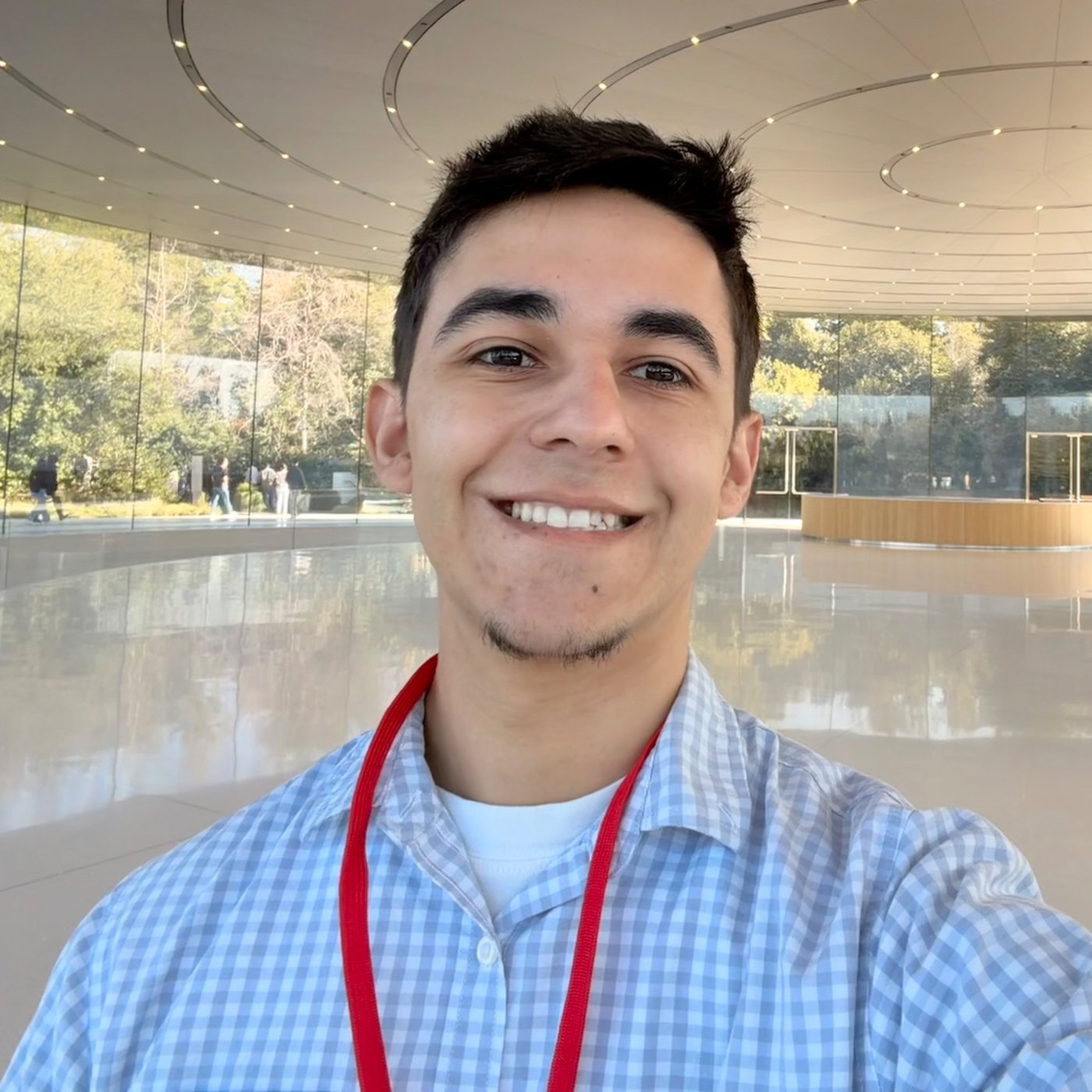 Christian Rodriguez smiling in a bright modern atrium.